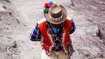 A guide walking in a colorful jacket and hat.